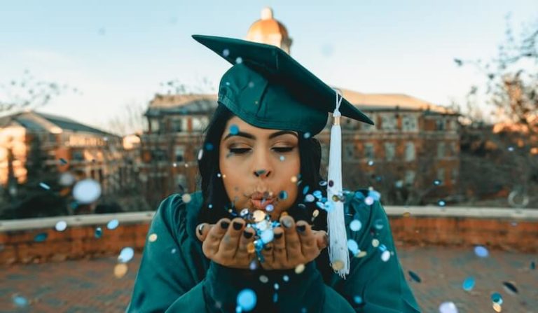 Image of new graduate blowing blue sequins
