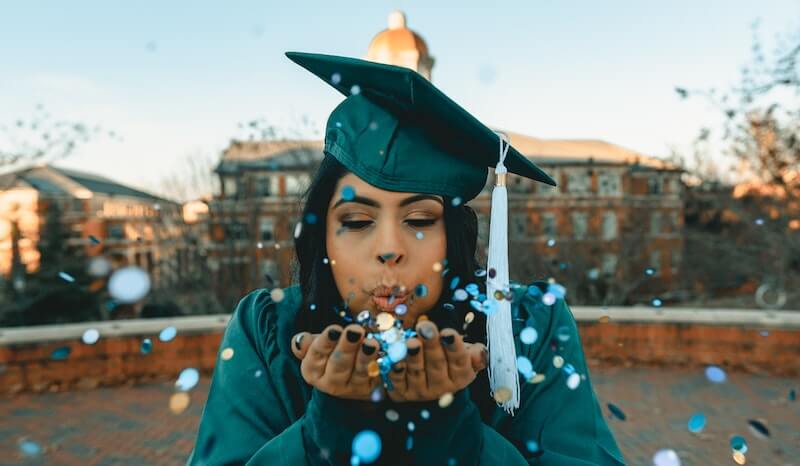 Image of new graduate blowing blue sequins