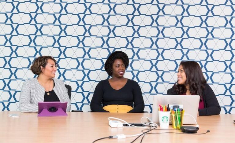 Image of three women talking at a conference table