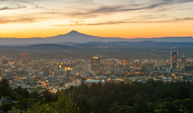 Portland, Oregon, at sunset, with a shadowy mountain in the distance.