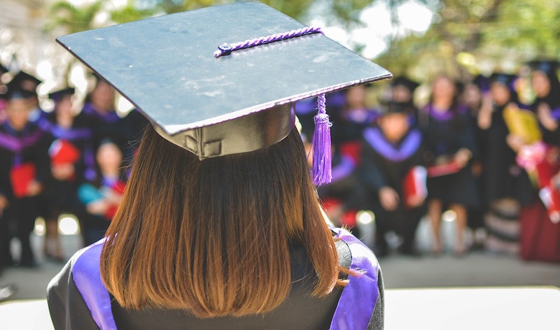 a person facing away from the camera wearing a graduation cap