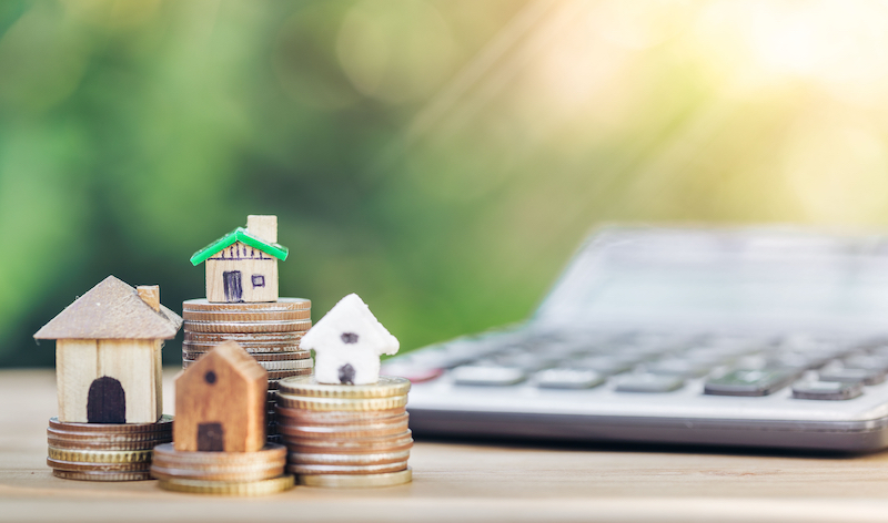 house is placed on top of coins, the concept of calculation to buy a house.