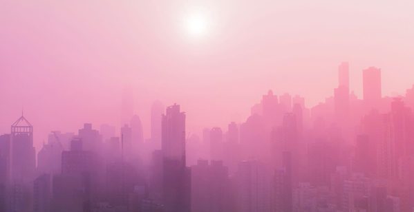 City skyline with pink fog and sunshine.