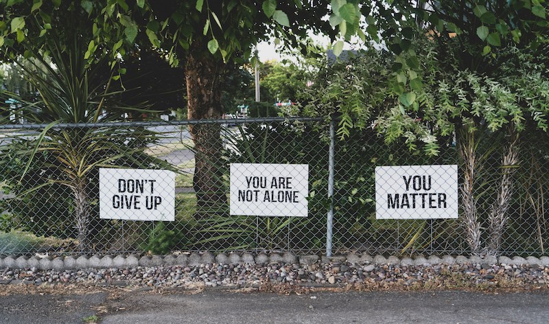 signs of encouragement that say "don't give up," "you are not alone," and "you matter."