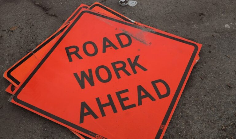 a public works related road works ahead sign laying on the ground